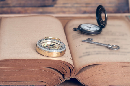 Compass on open old book