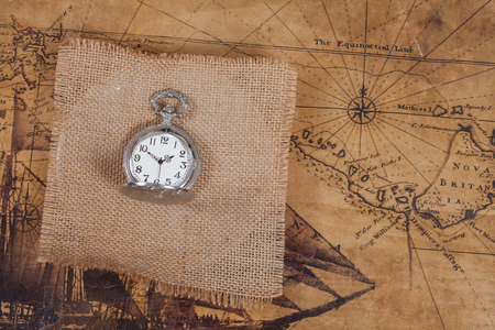 top view of old vintage pocket watch on burlap canvasの写真素材