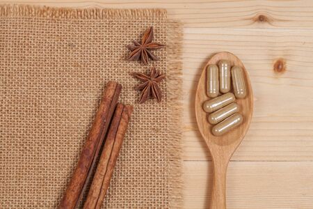 Herbal capsules on wooden spoon. herb for healthy 
living.の写真素材