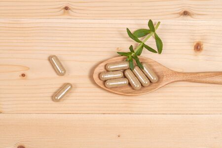 Herbal capsules on wooden spoon. herb for healthy 
living.の写真素材