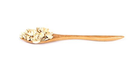 Wooden bowl with oats flakes pile on white background.の写真素材