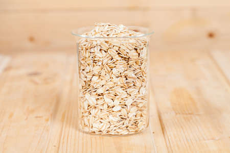 oats flakes pile in bottle on wood background.の写真素材