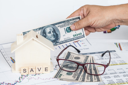 Miniature house with money and chartの写真素材