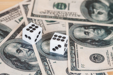 Two dices on wood table with US dollarの写真素材