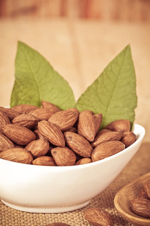 Almonds in bowl  on woodの写真素材
