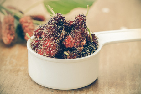 Mulberry in bowl on wooden background. Selective 
focus,の写真素材