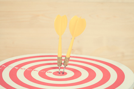 dart arrow and dartboard on wood backgroundの写真素材
