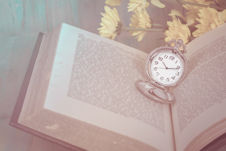 Pocket Watch over Age Book Background ,Time Concept, Image Tone.