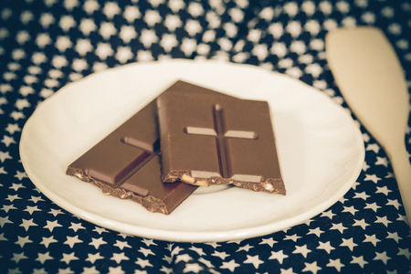 Chocolate bar on white disc with table clothの写真素材