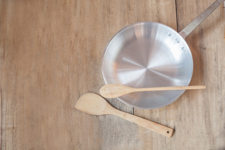 metal pan and flipper used in frying on woodの写真素材