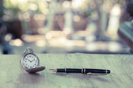 vintage pocket watch on wood tableの写真素材