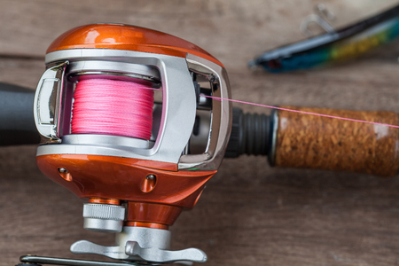 Fishing tackle - Baitcasting Reel, hooks and lures 
on  wooden backgroundの写真素材