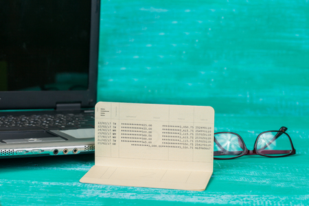 book bank with laptop on woodの写真素材