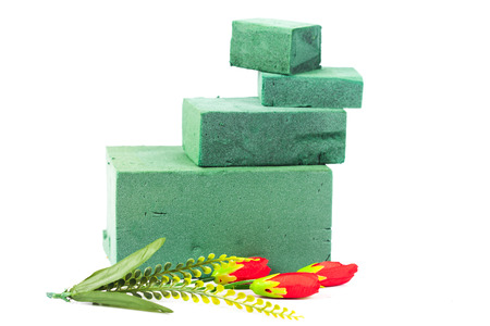 Green flora foam and gardener tool on white
