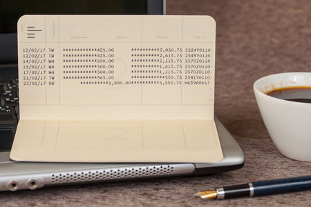 book bank with laptop on woodの写真素材