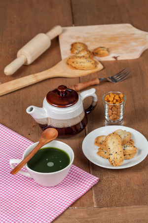 Hot and fresh green tea on wood with home made a small sweet cookie with black sesame.の写真素材