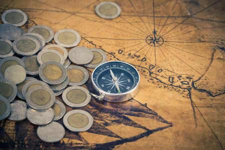 Compass and coins on old mapの写真素材