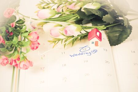 Wedding note on a calendar sets a reminder for the wedding day with flower.の写真素材