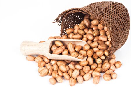 ground nut or peanut with wood spoon in basket on white background.