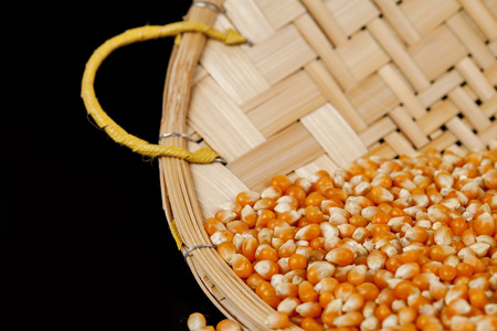 corn seed in bamboo wood basketry on black background