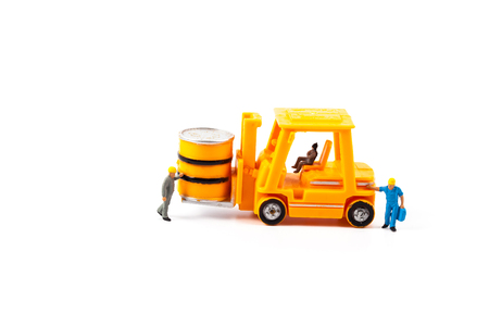 miniature worker and small forklift on white backgroundの写真素材