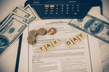 wording tax and miniature business toy with tax documents, money on table. Tax concept.の写真素材