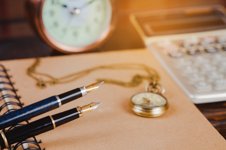 pocket watch over book note on wood table .の写真素材