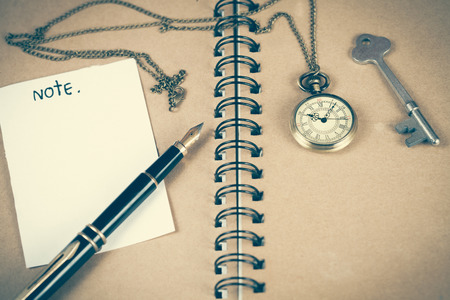 pocket watch over book note on wood table .の写真素材