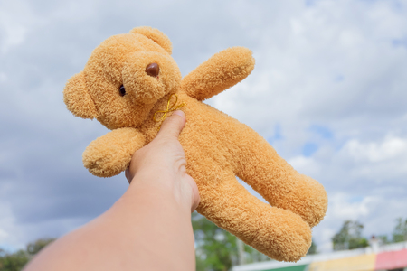 bear toy in hand with a blue sky .の写真素材