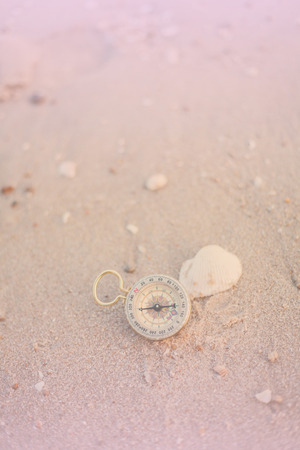 pocket compass on sea beach background.の写真素材