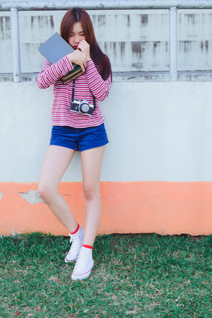 Fashion portrait of Hipster teen girl with text book inの写真素材