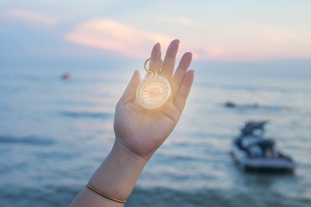 pocket compass in hand with sea background.の写真素材