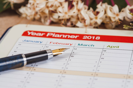 personal organizer or planner with fountain pen on wood table.の写真素材
