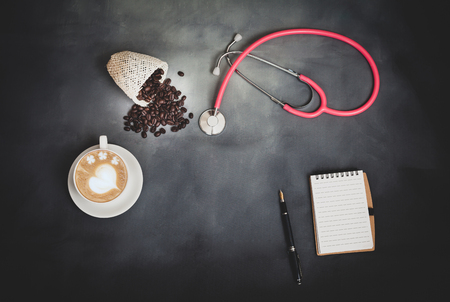 hot late art with coffee beans and stethoscope on background.の写真素材