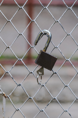 padlock hang on fence of iron door.

の写真素材