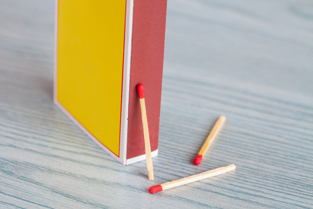 Matchstick out of matchbox on color wood table.の写真素材