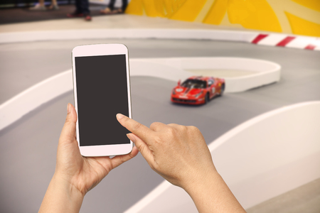 Men hand using smartphone on blurred racing car background .の写真素材