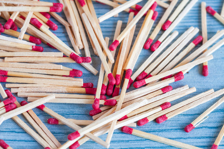 Matchstick out of matchbox on color wood table.