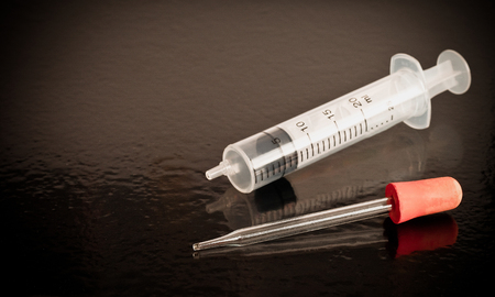 Pipette and Syringe science laboratory equipment on black table.の写真素材