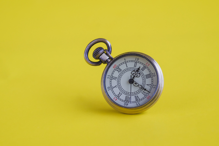 Vintage pocket watch on colour background.の写真素材