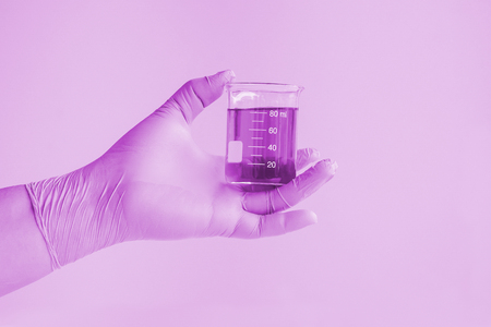 Laboratory glassware or test tube in hand for research.