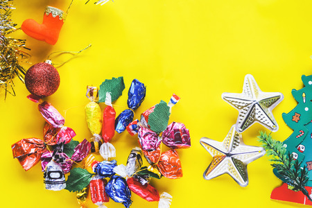 Christmas decoration. Santa's boot,red ball, fir tree branches with 


cones and christmas toys on yellow background. Top view.の写真素材