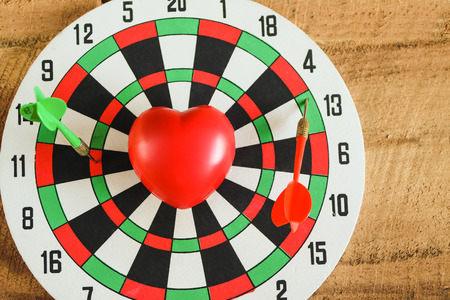 Red heart with color arrow on Wood texture background.の写真素材