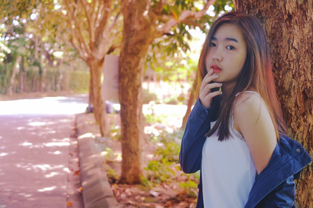 Asian Teen girl relax with summer colorful leave background.の写真素材