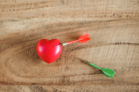 Red heart with color arrow on Wood texture background.の写真素材
