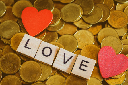 Love word on wooden blocks on gold coin money ,Valentine day concept.の写真素材