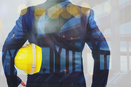 Double exposure of Engineer holding yellow helmet for workers security