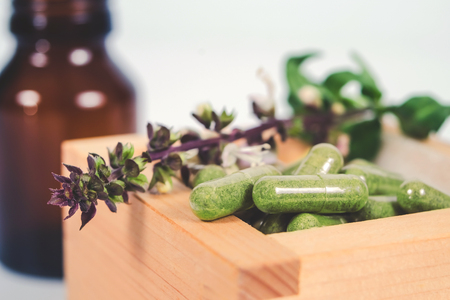 Alternative herb capsule in wood box ,health concept.の写真素材