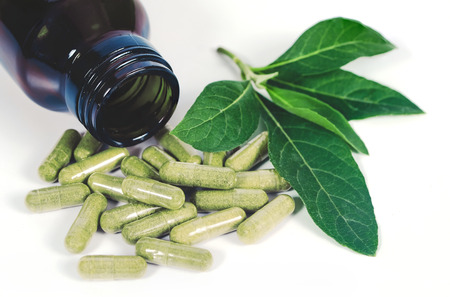 Alternative herb capsule spill out of bottle ,health concept.の写真素材