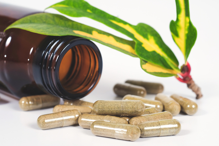 Alternative herb capsule spill out of bottle ,health concept.の写真素材